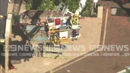 The worker, believed to be in his 20s, was said to have fallen through a roof baton and dropped more than two metres. Picture: 9NEWS.