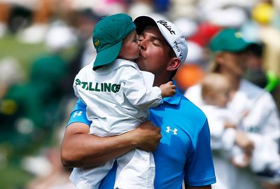 Scott Stallings gives his son a kiss inbetween holes. (AAP)