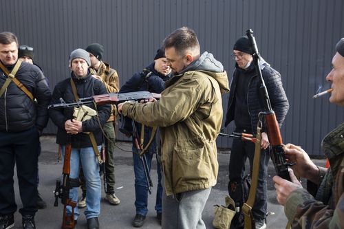 Civilian Members of a territorial defence unit fit their weapons to repel the Russian attacking forces in Kyiv, Ukraine, Saturday, Feb. 26, 2022. 