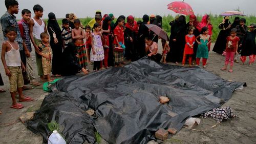 Bangladeshi villagers gather around bodies of Rohingya women and children after a boat capsized as they fled increasing violence in their home villages. (AAP