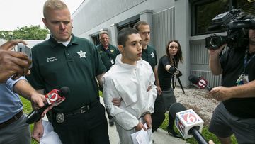 Marion County Sheriff's detectives escort a handcuffed and shackled Sky Bouche, 19, to a waiting patrol car. (AP)