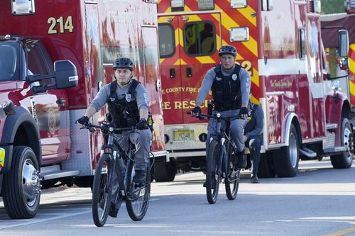 Patrouille de police à vélo près du palais de justice fédéral avant l'arrivée de l'ancien président Donald Trump, le jeudi 14 mars 2024, à Fort Pierce, en Floride.