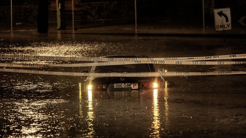 A p-plater's car is submerged in flood waters in Sydney