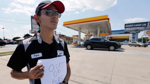 Employee Bryan Herrera holds a makeshift sign that reads, "Out of Gas," as he stands outside the Shell filling station where he works, in north Dallas. (AP)