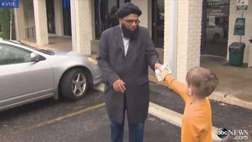 Jack hands his piggy bank savings to Faisal Naeem (Image: KVUE)