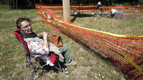 Loretta Jordan, of Omaha, Nebraska, watches workers dig for the suspected remains of children who once attended the Genoa Indian Industrial School in the USA.