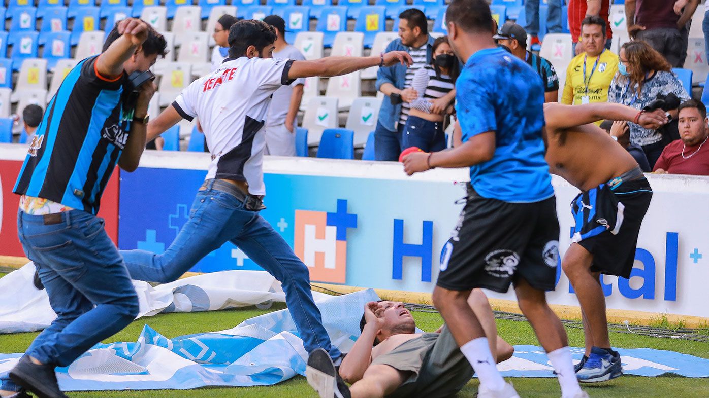 Fans fight during the 9th round match between Queretaro and Atlas as part of the Torneo Grita Mexico
