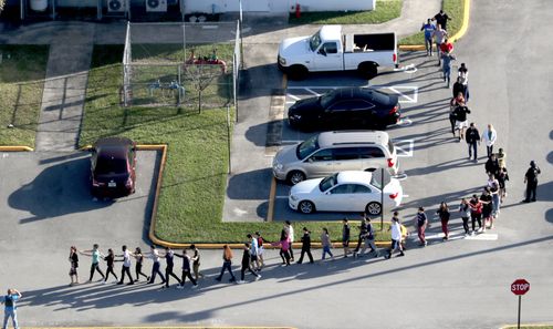 Students are led away from the classrooms by police at the height of the shootings. Picture: AAP