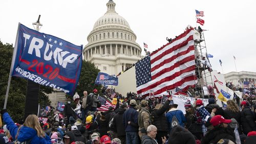 FILE - Violent insurrectionists loyal to President Donald Trump stand outside the US Capitol in Washington on January 6, 2021. 