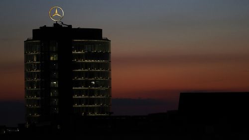 The sun sets behind the logo of German car maker Mercedes Benz in Munich, Germany, Wednesday, July 29, 2020. (AP Photo/Matthias Schrader)Alt