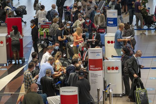 Des gens font la queue pour embarquer sur le vol Air France à destination de Paris à l'aéroport OR Tambos de Johannesburg, en Afrique du Sud, le vendredi 26 novembre 2021. 