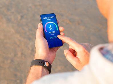 Man using daily activity tracking app on mobile phone.