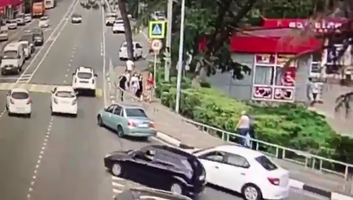 The car first veers into the wrong lane towards a crowd of oblivious pedestrians.