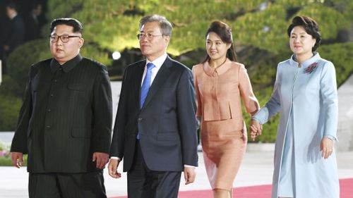 Kim and Mr Moon, Kim's wife Ri Sol Ju and Moon's wife Kim Jung Sook walk to the venue of a farewell event. (AP)