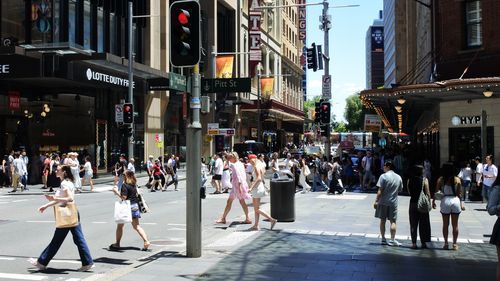 SYDNEY - DEZ 29 2024:Pedestres atravessando uma rua no distrito comercial central de Sydney, em Sydney, capital de Nova Gales do Sul, Austrália.