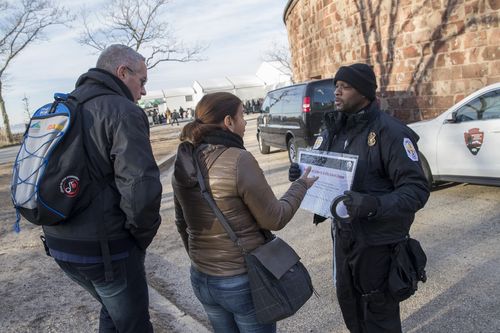 United States Park police officer Fernandez, right, informs tourists that the Statue of Liberty is closed. (AAP)