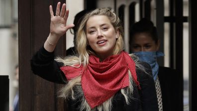 American actress Amber Heard smiles at the media as she arrives at the High Court in London, Thursday, July 23, 2020.