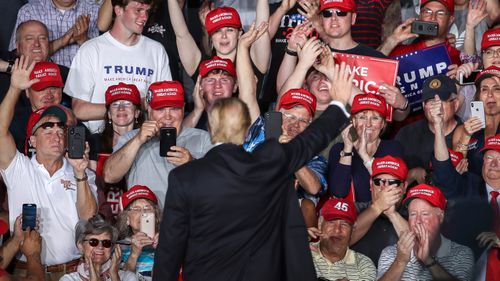 The crowd cheers as U. President Donald Trump waves at the end of a 'Make America Great Again' campaign rally at Williamsport Regional Airport, in Montoursville, Pennsylvania