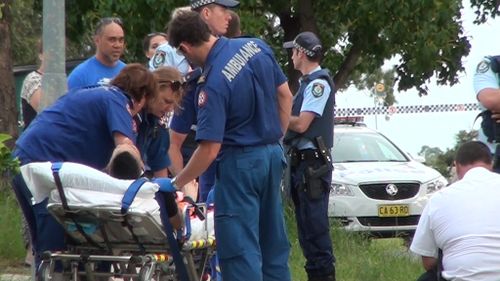 Paramedics attend to one of the wounded men in Bonnyrigg. (9NEWS)