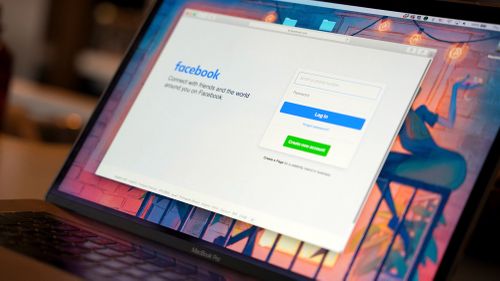 A Facebook login page appears on a computer