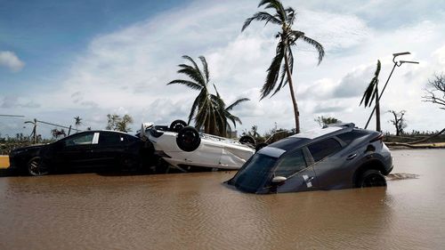 Cars lay partially underwater in the aftermath of Hurricane Otis