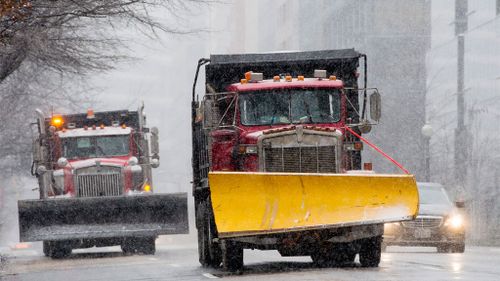 Snow plows drive down the street as the blizzard Jonas begins in Washington, DC. (AAP)