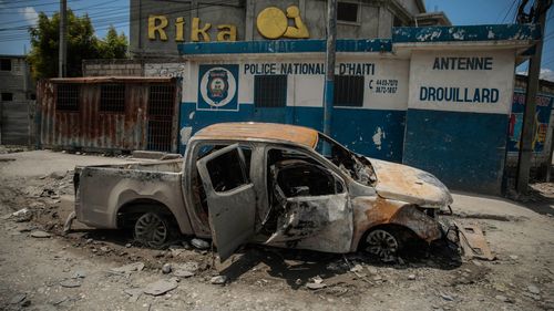 The shell of a charred police car, set on fire by gang members, sits in the Drouillard slum in Port-au-Prince, Haiti.