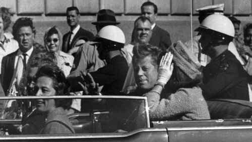 This Nov. 22, 1963 file photo shows President John F. Kennedy riding in motorcade with first lady Jacqueline Kennedy in Dallas, Texas.   