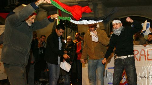 Palestinian protestors prepare to burn an Israeli flag in response to Operation Cast Lead. (Getty)