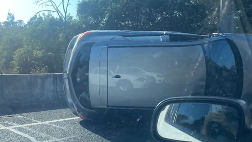 An overturned car is causing traffic chaos in Macquarie Park, Sydney.