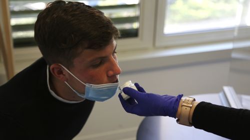 Yvan Sessa, un paciente, huele un pequeño tazón de perfume durante las pruebas en una clínica en Niza, Francia, el lunes 8 de febrero de 2021. 