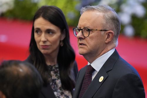 Australia's Prime Minister Anthony Albanese, right, and New Zealand's Prime Minister Jacinda Ardern react during ASEAN - East Asia Summit in Phnom Penh, Cambodia, Cambodia, Sunday, Nov. 13, 2022. (AP Photo/Vincent Thian)