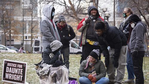 Activists watch the trial of former Brooklyn Center police Officer Kim Potter, Friday Dec. 17, 2021, outside the Hennepin County Courthouse in Minneapolis. Potter, who is white, is charged with first- and second-degree manslaughter in the shooting of Daunte Wright, a Black motorist, in the suburb of Brooklyn Center. Potter has said she meant to use her Taser  but grabbed her handgun instead  after Wright tried to drive away as officers were trying to arrest him. (AP Photo/Christian Monterrosa)