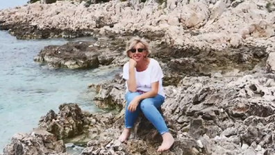 Susan Francis sitting on rocks on holiday