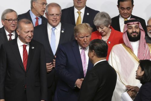 Prime Minister Scott Morrison looks on as President of the United States Donald Trump and President of China Xi Jinping shake hands during the 'family photo' at the G20 Summit in Osaka, Japan, in 2019.