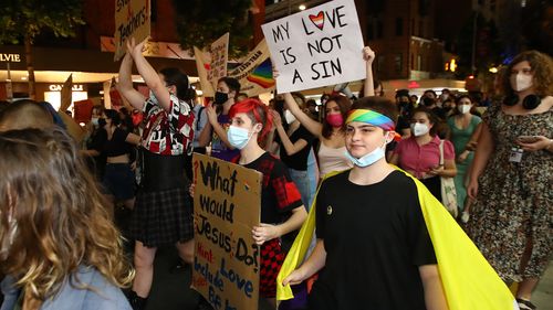 Protestors march as they hold signs during a rally against the Religious Discrimination Bill on February 04, 2022 in Brisbane