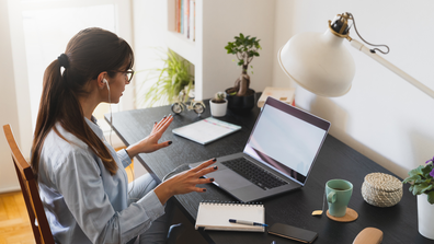 Woman sitting at a desk appearing to be working from home