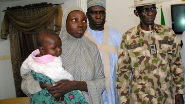 Rescued Chibok schoolgirl Maryam Ali Maiyanga (2-L) carries her 10-month-old son while arriving at the Government House, after her rescue on November 5, 2016. (AFP)