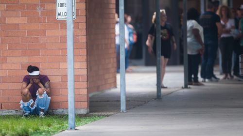 A pupil seeks out a quiet place after the atrocity. Picture: AP