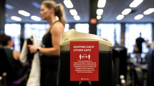 A sign warns gym-goers to social distance while working out 