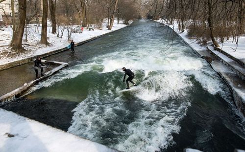 Brave surfers take to the wild water the Eisbach creek in the English Garden park in Munich, Germany. (AP).