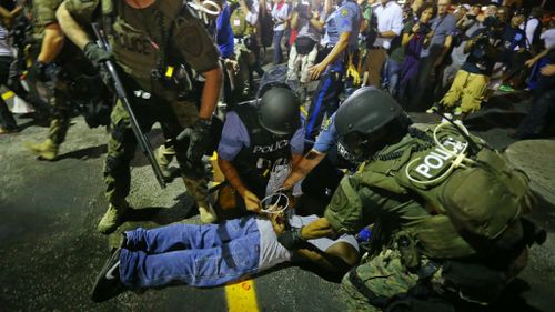 Police arrest a man after breaking up a protest in Ferguson. (AP)