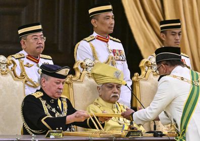 Sultan of Johor, Sultan Ibrahim Iskandar, left, receives documents from Malaysia's Prime Minister Anwar Ibrahim during the oath taking ceremony as the 17th King of Malaysia at the National Palace in Kuala Lumpur on Wednesday, Jan. 31, 2024.  