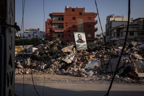  Debris is seen by the side of the road with a portrait of a Hezbollah fighter who was killed in the attack by an Israeli airstrike that destroyed the building four days earlier, where a total of six people died according to a Hezbollah spokesperson on November 1, 2024 in Tyre, Lebanon. In recent weeks, Israeli airstrikes have become more frequent in this southern Lebanese city, which was previously a refuge for displaced people from areas farther south near the border