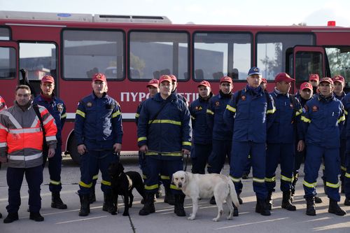 Greek firefighters with dogs wait to board a military plane at Elefsina Air Force Base, in western Athens, Greece, Monday, Feb. 6, 2023. 