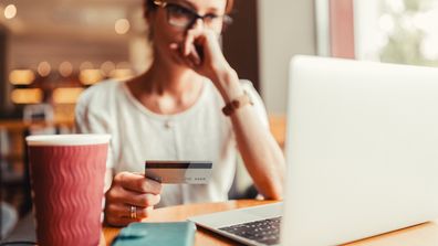 Woman in a cafe having problems with her credit card.