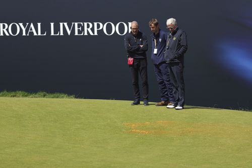 Officials look at orange material thrown down by protesters the 17th hole during the second day of the British Open Golf Championships at the Royal Liverpool Golf Club in Hoylake, England, Friday, July 21, 2023. 