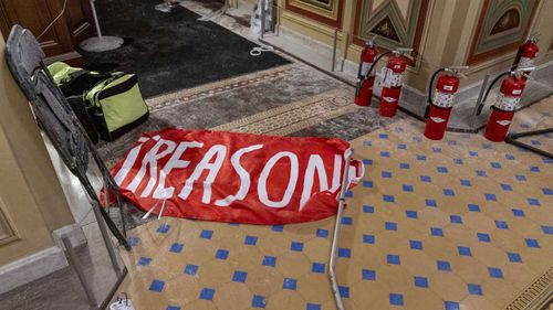 A banner reading 'Treason' is left on the floor of the US Capitol.