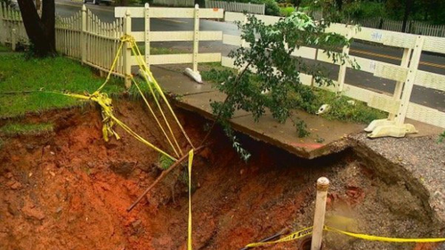 A neighbour is worried about a sinkhole that is growing bigger next to his property. 