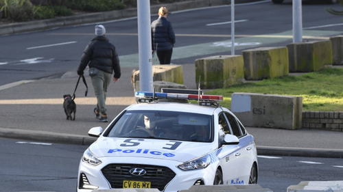 SYDNEY, AUSTRALIA - JULY 11: A police car patrols along Bondi Beach on July 11, 2021 in Sydney, Australia. Lockdown restrictions have been tightened across NSW as COVID-19 cases continue to emerge in the community.  Lockdown restrictions are in place across Greater Sydney, the Blue Mountains, the Central Coast and Wollongong with all residents subject to stay-at-home orders are only permitted to leave their homes for essential reasons, including purchasing essential goods, accessing or providing
